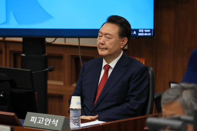 윤석열 전 대통령이 21일 서울 서초동 서울중앙지법에서 열린 내란 우두머리 혐의 형사재판 두 번째 공판에 출석해 피고인석에 착석해 있다. 사진공동취재단