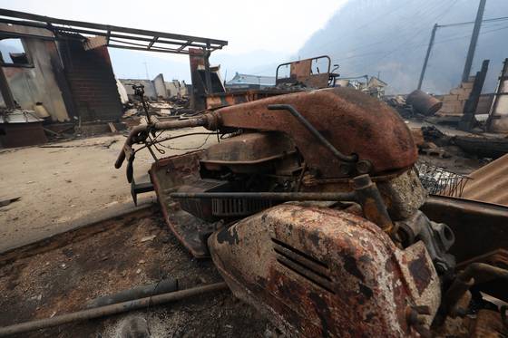 지난달 27일 경북 청송군 파천면 지경리에서 밤새 번진 산불로 무너진 가옥 앞에 불에 탄 농기계가 세워져 있다. 연합뉴스