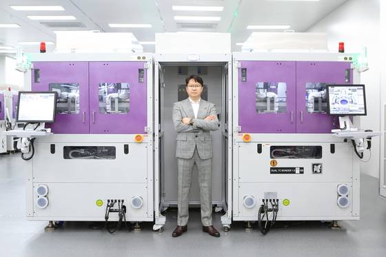 한미반도체의 차세대 HBM용 본딩 장비 ‘TC 본더 그리핀 슈퍼 본딩 헤드’. 곽동신 한미반도체 회장이 장비 앞에서 포즈를 취하고 있다. 사진 한미반도체