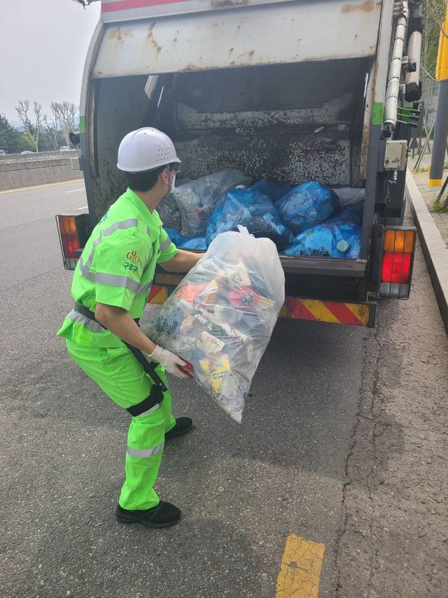 서울 구로구 환경미화원이 근력증강 착용형(웨어러블) 로봇을 착용하고 쓰레기봉투를 청소차로 옮기고 있다. 구로구청 제공