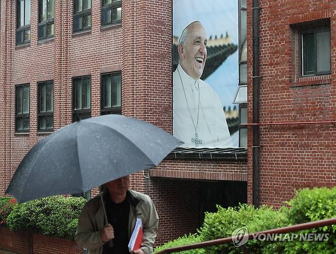 프란치스코 교황 선종 (서울=연합뉴스) 서명곤 기자 = 22일 서울 중구 명동대성당 영성센터 건물 외벽에 프란치스코 교황의 사진이 걸려있다. 서울대교구 주교단은 이날 오후 주교좌 명동대성당 지하성당에 프란치스코 교황 빈소를 마련한다고 밝혔다. 염수정 추기경, 정순택 대주교, 구요비 주교, 이경상 주교를 비롯한 주교단 조문 이후 오후 3시부터 일반인들도 조문할 수 있다. 2025.4.22 seephoto@yna.co.kr