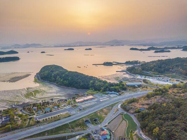 경남 남해군 고현면 차면리 이순신바다공원 너머로 해가 지면서 일대를 주홍빛으로 물들이고 있다. 가운데 튀어나온 지형에 이순신 장군의 유언비, 이락사, 첨망대가 있다.