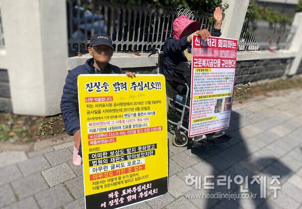 24일 오전 근로복지공단 제주지사 앞 거리에서 피켓을 들고 억울함을 호소하고 있는 김○○씨(오른쪽)와 남편(왼쪽). ⓒ헤드라인제주