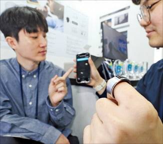 브이터치의 음성 인식 웨어러블 디바이스 ‘위즈퍼링’을 체험하는 관람객들. /이솔 기자