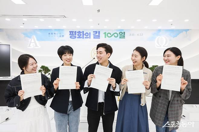 신천지예수교회 성도들이 인 맞음 확인 시험지를 들고 밝게 웃고 있다. (사진제공=신천지예수교회)