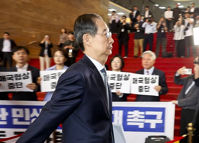 <대통령 대행의 ‘시정연설 하러 가는 길’> 한덕수 대통령 권한대행 겸 국무총리가 24일 국회에서 열린 추가경정예산 시정연설을 위해 국회 본청으로 들어서는 동안 조국혁신당, 진보당 등 야 4당 의원들이 일방적 통상협상 중단과 민생 추경 확대를 촉구하는 팻말을 들고 있다. 국회사진기자단