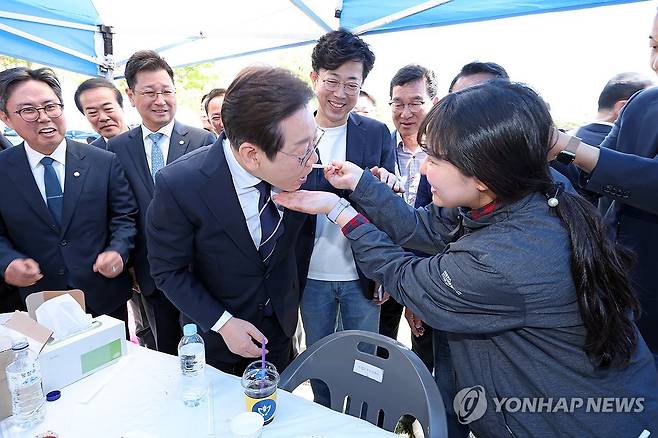 남도 김치 맛보는 이재명 후보 (광주=연합뉴스) 형민우 기자 = 더불어민주당 이재명 대선 경선 후보가 26일 광주 광산구 호남대학교에서 열린 광주전남기자협회 체육대회를 찾아 한 참석자가 건넨 김치를 맛보고 있다. 2025.4.26 minu21@yna.co.kr