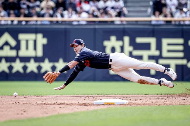 롯데 자이언츠 박진이 27일 서울에서 열린 2025 프로야구 두산 베어스전에서 힘차게 공을 던지고 있다(위). 롯데 2루수 고승민이 몸을 던져 공을 잡아내고 있다. 롯데 자이언츠 제공