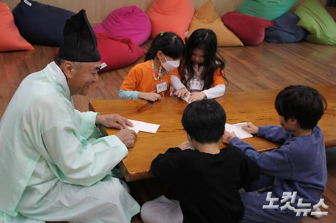 이종욱 할배샘과 초등학교 학생들이 딱지를 접고 있다. 반웅규 기자