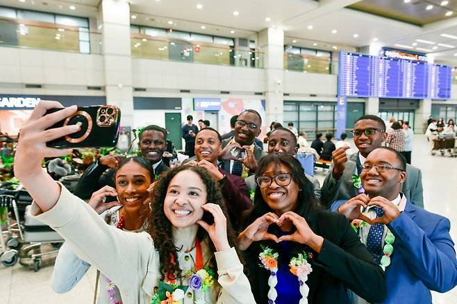 82차 해외성도방문단으로 방한한 미국, 캐나다, 멕시코 등지 하나님의 교회 신자들이 인천국제공항으로 입국했다. 한국 신자들이 걸어준 사탕목걸이를 하고 사진을 찍고 있다. 하나님의교회 세계복음선교협회 제공