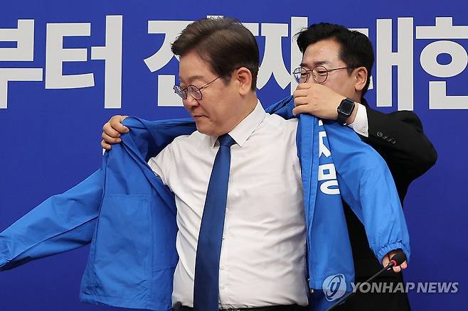 선거운동용 점퍼 입는 이재명 대선 후보 (서울=연합뉴스) 김주성 기자 = 더불어민주당 박찬대 당대표 직무대행 겸 원내대표가 28일 서울 여의도 국회에서 열린 최고위원회의에서 이재명 대선 후보에게 선거운동용 파란색 점퍼를 입혀주고 있다. 2025.4.28 utzza@yna.co.kr