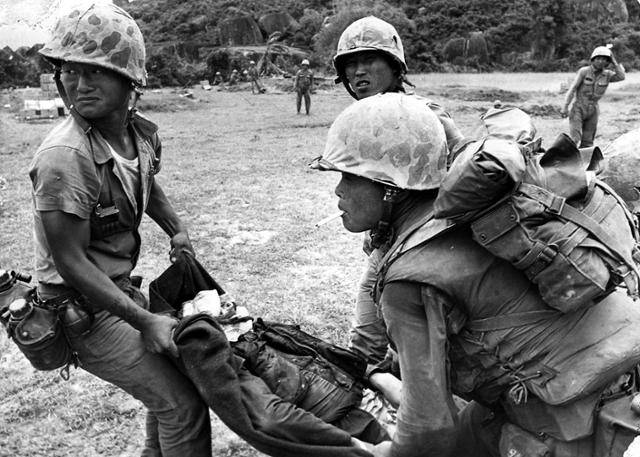 1966년 1월 2일 베트남전에 파병된 청룡부대원들이 부상병을 헬기로 옮기고 있다. 한국일보 자료사진