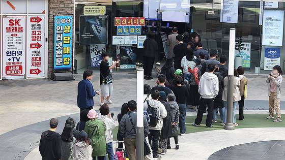 가입자 유심(USIM) 정보를 탈취당한 SK텔레콤이 유심 무료교체 서비스를 시작한 지 이틀째인 29일 서울 시내 한 SKT 대리점에 시민들이 줄을 서서 교체 순서를 기다리고 있다. 연합뉴스