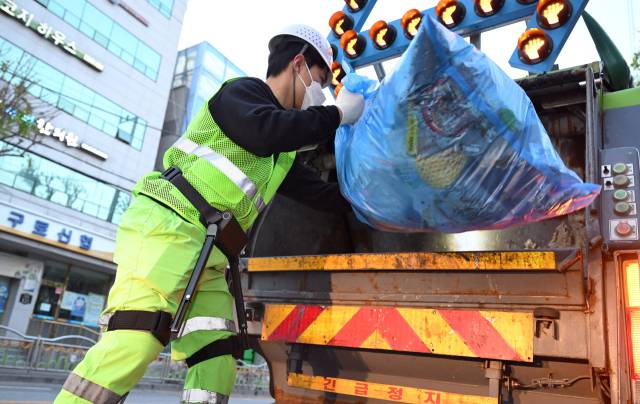 황동건 서울경제신문 기자가 이달 28일 새벽 서울 구로구 거리에서 ‘근력 증강 착용형 로봇’을 착용한 채 생활 폐기물을 처리하고 있다. 오승현 기자