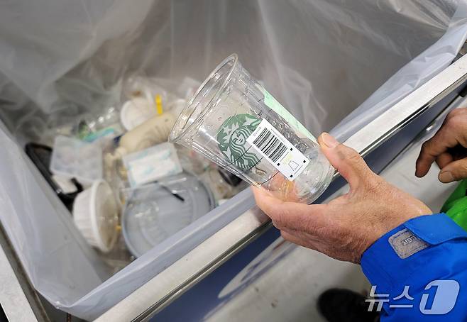 함덕리 재활용도움센터 도우미가 쓰레기통에 버려진 보증금제 라벨이 붙은 일회용컵을 수거하고 있다. 2025.4.30/뉴스1
