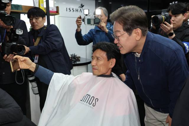 민심을 듣는 '골목골목 경청 투어'를 시작한 더불어민주당 이재명 대선 후보가 1일 경기도 북부 접경지역인 연천군 전곡읍에서 미용실을 찾아 손님과 대화하며 사진을 찍고 있다. 연합뉴스