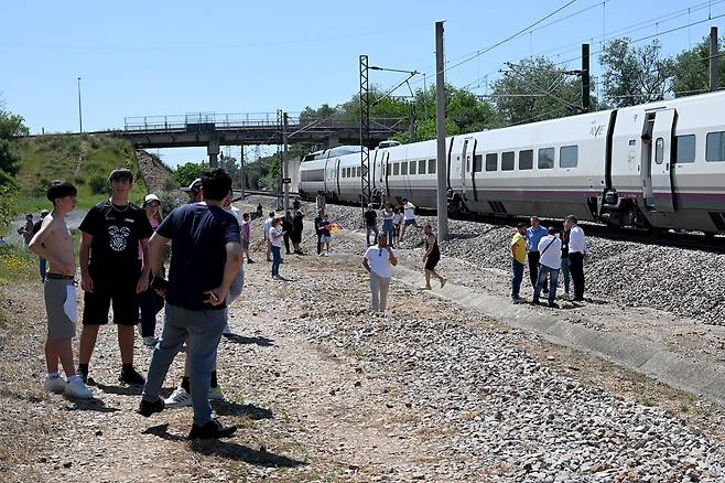 이베리아 반도 전체와 프랑스 남부에 영향을 미친 대규모 정전 사태가 발생한 4월 28일 스페인 코르도바 인근에서 승객들이 정전으로 멈춰선 고속 열차에서 내려 옆에 서 있다./AFP 연합뉴스