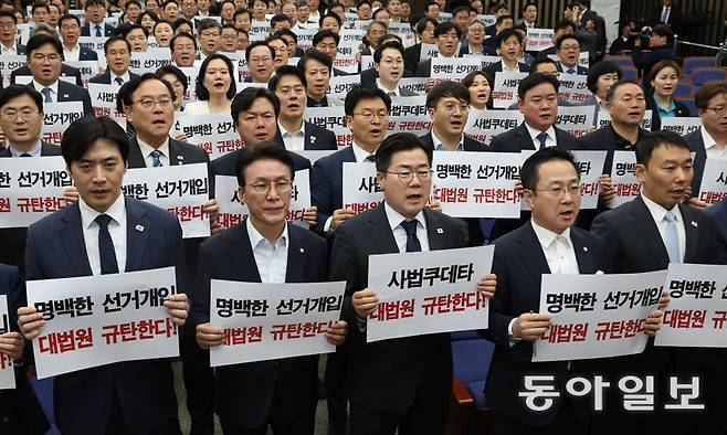 더불어민주당 의원들이 1일 오후 긴급 의원총회를 열고 이재명 후보의 공직선거법 위반 혐의 2심 무죄 판결을 파기환송한 대법원을 규탄하는 손팻말을 들어 보였다. 박찬대 원내대표(앞줄 가운데)는 “3시에 대법원이 파기환송을 선고하고, 4시에 한덕수 대통령 권한대행 국무총리가 사퇴했다. 이 무슨 짜고 치는 고스톱인가”라고 했다. 이훈구 기자 ufo@donga.com