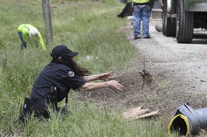 지난달 29일(현지 시각) 미국 텍사스주 고속도로에 10센트 동전 신권을 싣고 가던 수송차량이 전복됐다. 사진은 직원들이 동전을 쓸어담고 있는 모습. 사진=AP 연합뉴스