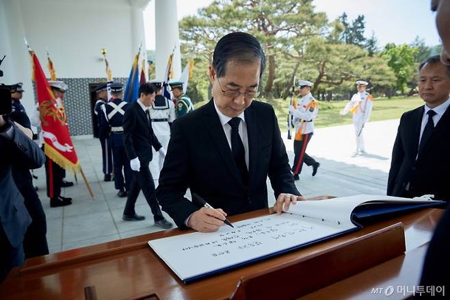 (서울=뉴스1) = 대선 출마를 선언한 한덕수 전 국무총리가 2일 서울 동작구 국립서울현충원 참배 후 방명록을 작성하고 있다. '대한민국이 갈등과 혼란을 넘어 앞으로, 오직 앞으로 나아갈 수 있도록 전력을 다하겠다'고 적었다. (한덕수 캠프 제공, 재판매 및 DB 금지) 2025.5.2/뉴스1 Copyright (C) 뉴스1. All rights reserved. 무단 전재 및 재배포, AI학습 이용 금지. /사진=(서울=뉴스1)