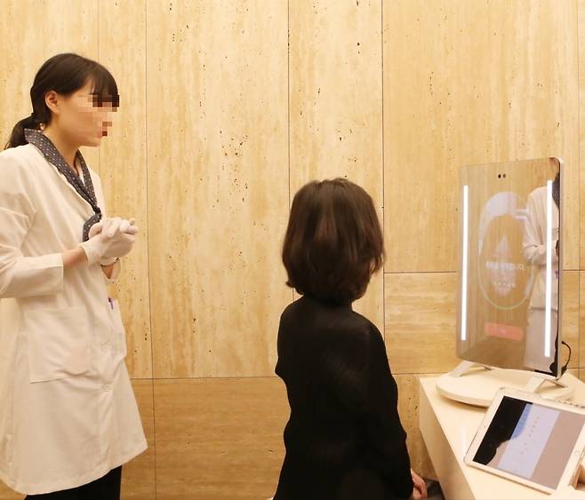 아누라 매직미러를 체험하는 모습. 사진=현대백화점 제공