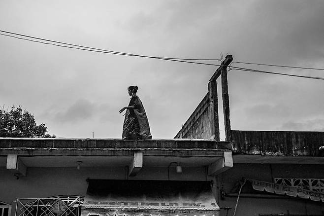 비 내리는 이른 아침 화물 열차를 기다리던 한 여성이 검은 비닐 봉투를 걸치고 지붕 위를 걷고 있다. 검은 비닐 봉투는 화물 열차를 타려는 이민자들에게 추위와 비를 막아주는 좋은 도구다. 2024. 12. 멕시코 베라크루즈 주 /사진가 양희석