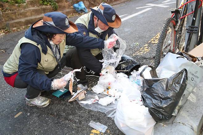 서울 관악구 소속 무단투기보안관이 일반 쓰레기 봉투 속에 음식물이나 재활용품이 있는지 확인 작업을 하고 있다. 관악구청 제공