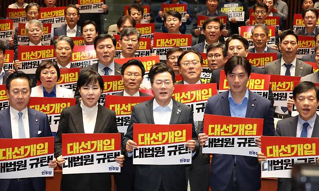 더불어민주당 박찬대 대표 직무대행 겸 원내대표와 의원들이 4일 서울 여의도 국회에서 열린 긴급 의원총회에서 피켓을 들고 구호를 외치고 있다. 뉴시스