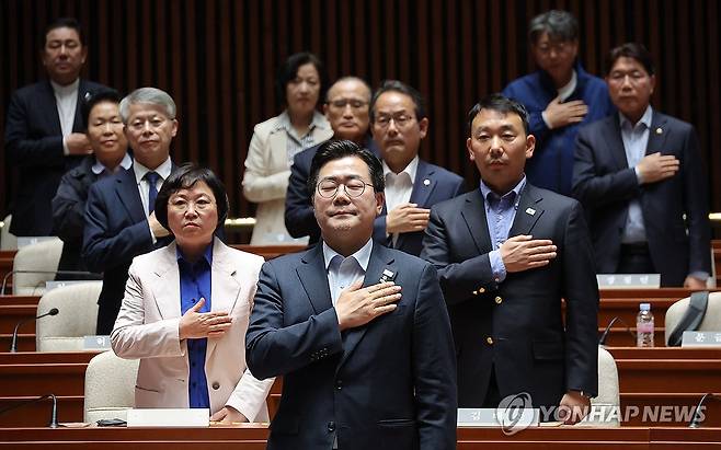 주말 긴급 의원총회 연 더불어민주당 (서울=연합뉴스) 류영석 기자 = 더불어민주당 박찬대 원내대표를 비롯한 의원들이 4일 국회에서 열린 긴급 의원총회에서 국기에 경례를 하고 있다. 2025.5.4 ondol@yna.co.kr