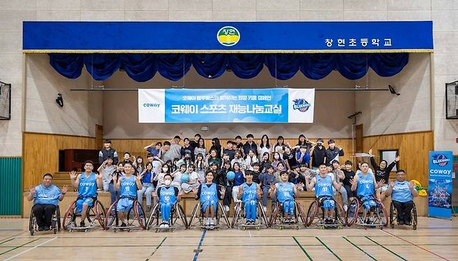 코웨이 블루휠스 휠체어농구단이 2일 창현초등학교에서 휠체어 농구 체험교실을 진행한 후 기념촬영을 하고 있다. <코웨이>