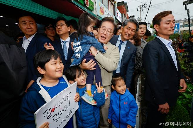 (옥천=뉴스1) 안은나 기자 = 이재명 더불어민주당 대통령 후보가 골목골목 경청투어 이틀차인 6일 오후 충북 옥천군 공설시장을 찾아 아이를 안고 있다. 2025.5.6/뉴스1 Copyright (C) 뉴스1. All rights reserved. 무단 전재 및 재배포, AI학습 이용 금지. /사진=(옥천=뉴스1) 안은나 기자