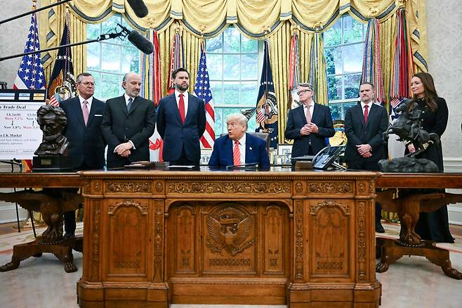 도널드 트럼프(가운데) 미 대통령이 8일 백악관 집무실에서 하워드 러트닉(왼쪽 둘째) 상무장관, JD 밴스 부통령(왼쪽 셋째), 제이미슨 그리어(오른쪽 둘째) USTR 대표 등이 참석한 가운데 영국과 관세 합의를 발표하고 있다./AFP연합뉴스