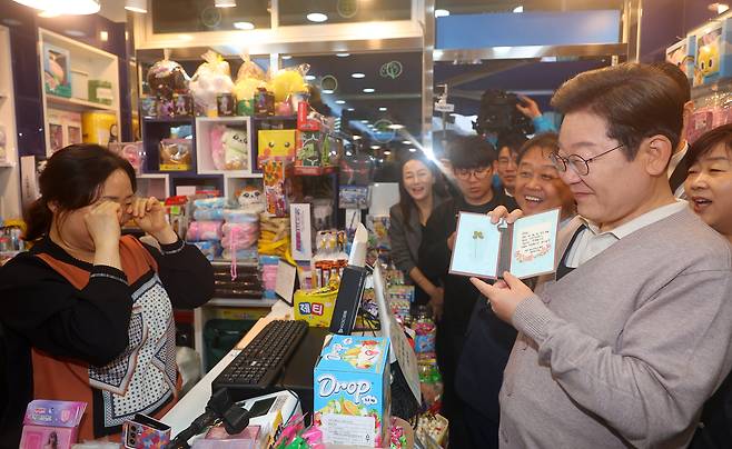 더불어민주당 이재명 대선 후보가 제3차 골목골목 경청투어로 경북지역 방문에 나선 9일 경북 경주시의 한 문방구를 방문해 가게 상인으로부터 응원 메시지가 적힌 카드를 받고 있다./연합뉴스