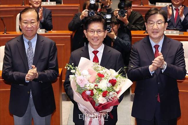 김문수 국민의힘 대선 후보가 9일 국회에서 열린 국민의힘 의원총회에서 권영세 비상대책위원장과 권성동 원내대표로부터 꽃다발을 받고 있다. ⓒ데일리안 홍금표 기자