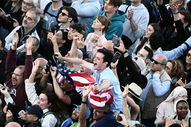 첫 미국인 출신 교황 레오 14세가 선출되자 8일 바티칸 성 베드로 광장에 모인 사람들이 성조기를 흔들고 있다. 바티칸=AFP 연합뉴스