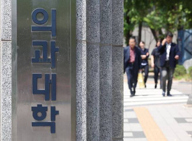 시민들이 한 의과대학 정문 앞을 지나가고 있다.