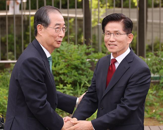 김문수 국민의힘 대선후보(오른쪽)와 한덕수 무소속 대선 예비후보가 8일 서울 국회 사랑재에 위치한 커피숍에서 만나 악수하고 있다. ⓒ연합뉴스