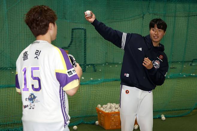 두산 베어스 투수 홍민규(오른쪽)가 지난 6일 잠실 LG 트윈스전에 시구자로 나선 브롤스타즈 크리에이터 홀릿에게 투구하는 동작을 가르쳐주고 있다. /사진=두산 베어스 제공