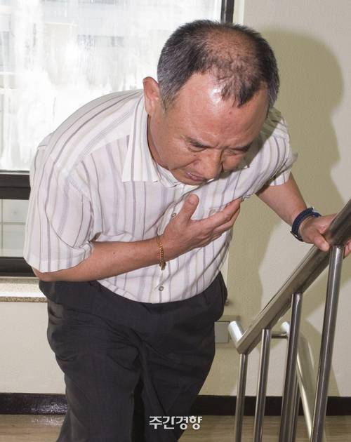 계단을 오르던 한 남성이 가슴에 통증을 느끼며 괴로워하는 이미지. 경향신문 자료사진