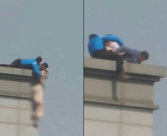 지난 2일 오후 3시17분쯤 서울 강남구 역삼동 19층 오피스텔 건물 옥상에서 한 여성이 투신 소동을 벌이다 약 2시간 만에 구조됐다. 여성의 팔을 잡은 파란 상의의 남성이 경찰특공대 신모 경위(38), 남색 상의의 남성이 경찰특공대 최모 경위(39)다. 사진 독자