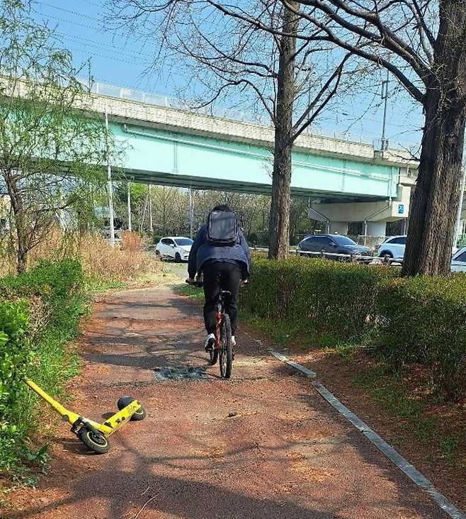 한 자전거 이용자가 파손돼 울퉁불퉁한 상태인 자전거도로를 통과하고 있다.
