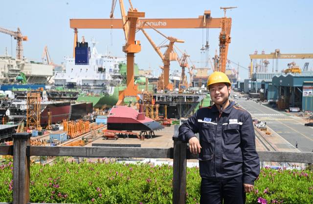 한화오션 신입사원 장민씨가 조선소를 배경으로 포즈를 취하고 있다./성승건 기자/