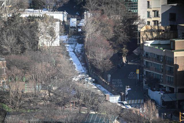1월 9일 서울 용산구 한남동 대통령 관저에서 경호처 관계자들이 입구에 승용차와 경찰차로 차벽을 세워 경계를 강화하고 있다. 정다빈 기자