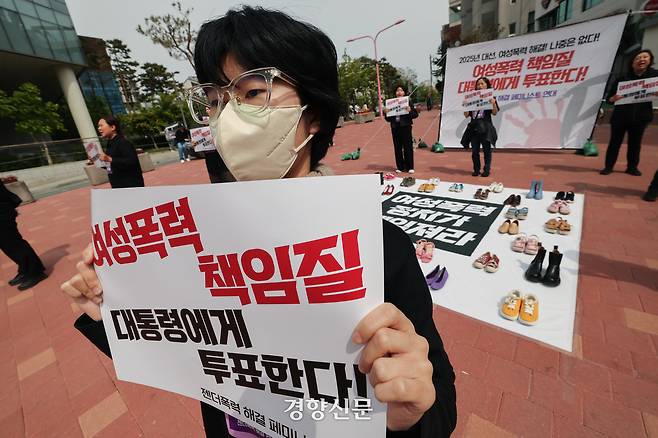 서울여성회 페미니스트 대학생연합동아리 회원들이 지난달 27일 서울 마포구 홍대입구역 앞에서 열린 ‘2025 대선, 여성폭력 해결! 나중은 없다!’ 캠페인에서 여성폭력 희생자들을 상징하는 신발을 놓고 다이-인(Die-in) 퍼포먼스를 하고 있다. 성동훈 기자