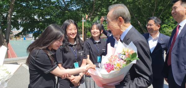 이명박 전 대통령이 14일 모교인 포항동지고등학교를 방문한 가운데, 동지여고 학생회 간부 학생이 화환을 전달한 후 악수하는 모습. 황영우 기자