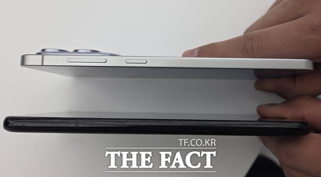 취재진이 '갤럭시S25 엣지'(위·5.8㎜)와 '갤럭시S21 플러스'(7.7㎜)의 두께를 비교해 보고 있다. /이성락 기자