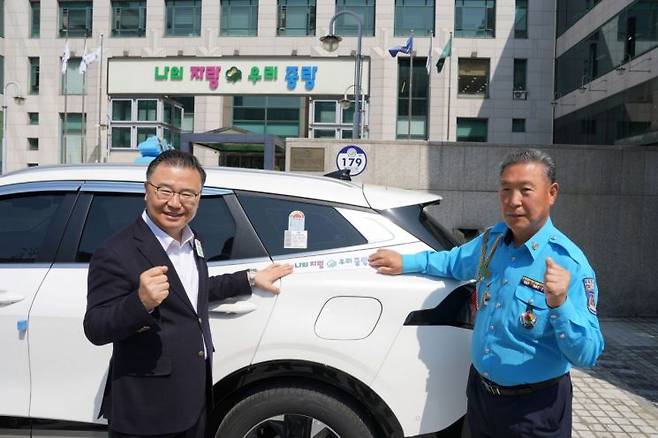 슬로건 스티커가 부착된 택시 앞에 선 류경기 중랑구청장과 택시 운수종사자