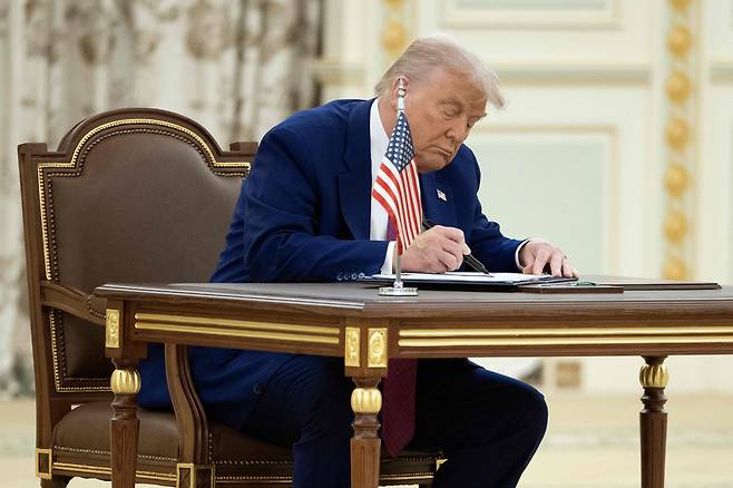 도널드 트럼프 미국 대통령이 13일 리야드에서 사우디 왕세자와의 양자 회담에서 합의문에 서명하고 있다./AFP 연합뉴스