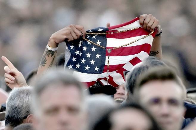 레오 14세가 콘클라베에서 선출된 8일 바티칸 성 베드로 광장에서 한 시민이 미국 출신 교황 선출을 축하하는 의미로 성조기를 펼쳤다. 바티칸시티=AP 뉴시스