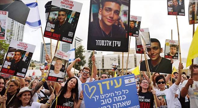 < 이스라엘 시민들 “美인질 석방 환영” > 이스라엘 시민들이 12일(현지시간) 텔아비브 인질 광장에 나와 이스라엘·미국 이중 국적 인질 에단 알렉산더의 석방을 환영하고 있다. 팔레스타인 무장정파 하마스는 도널드 트럼프 미국 대통령의 중동 순방을 앞두고 이날 미국 국적의 인질을 풀어줬다. 알렉산더는 미국 뉴저지 출신으로, 가자지구에 억류된 마지막 미국인 생존자로 알려졌다. AFP연합뉴스